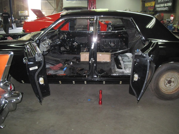 Suicide doors open — gutted shell in the shop during assembly