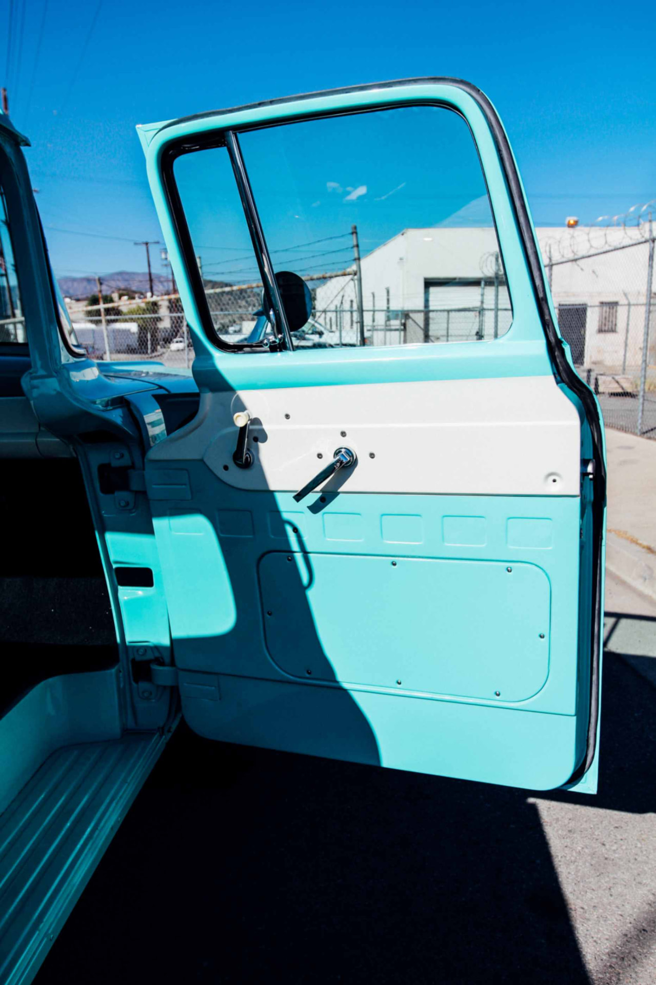 Open door showing the turquoise door panel and window crank