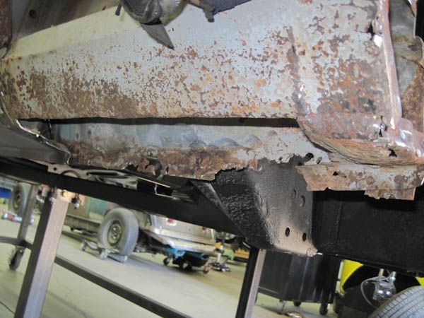 Original rocker-panel rust exposed before repair
