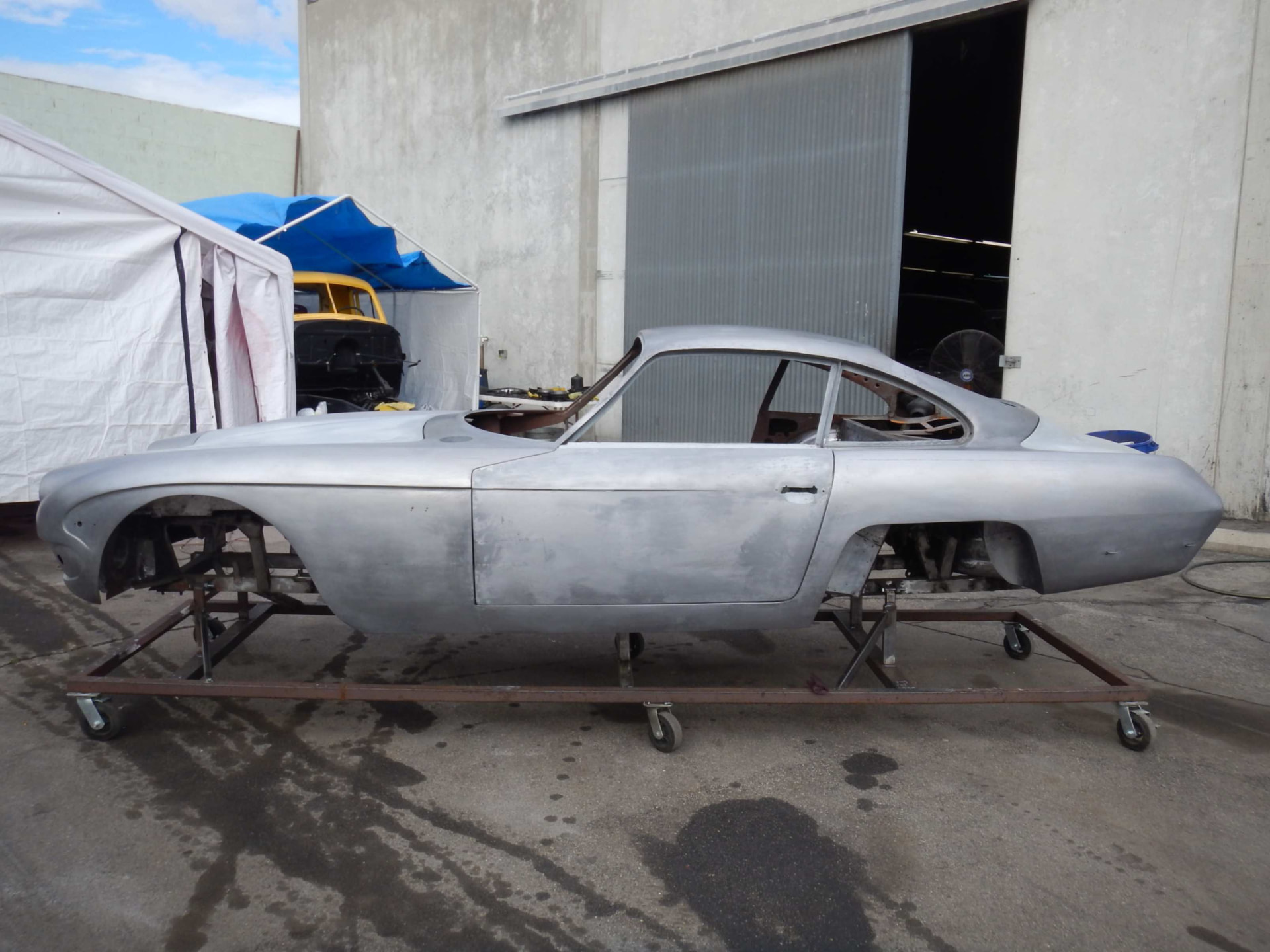 Bare metal body shell on a rolling stand