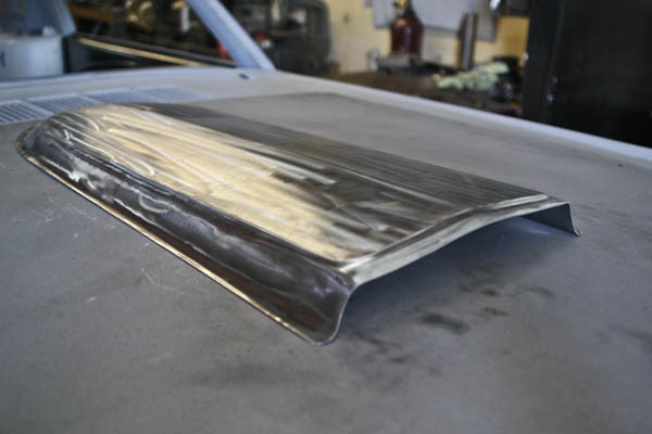 Hand-formed hood scoop in bare metal