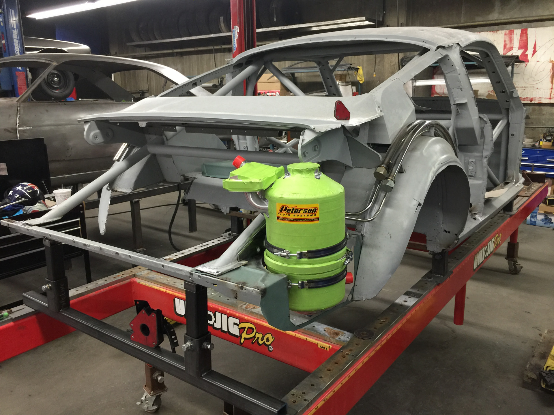 Bare shell on the jig — dry sump tank and cage