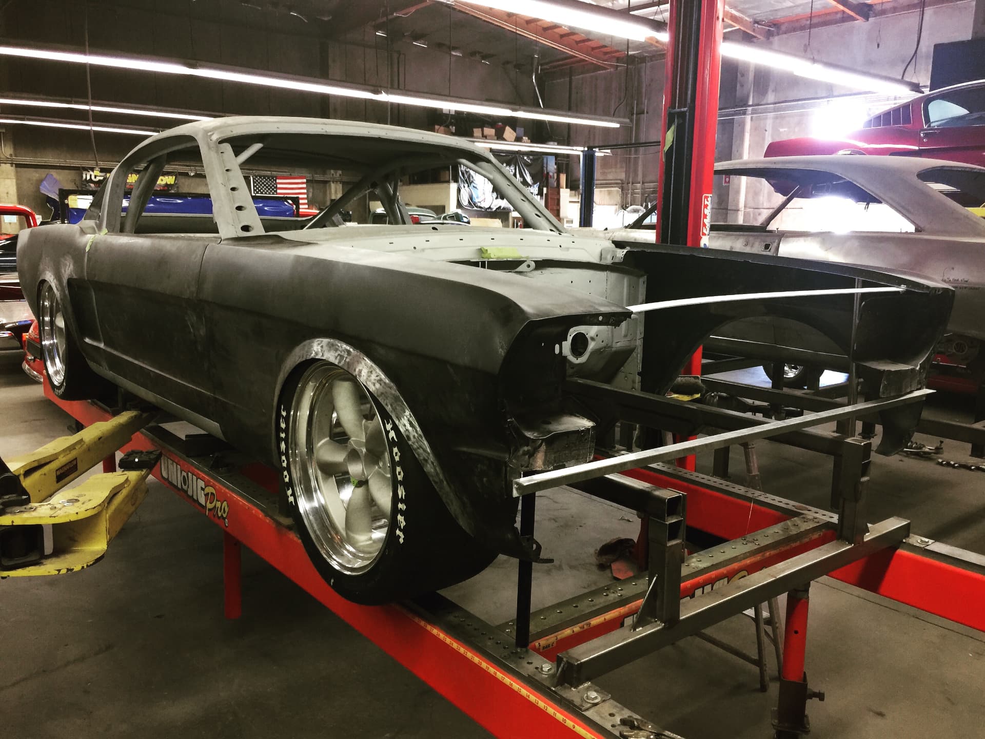 Mockup on the jig — wide Hoosiers and flared bodywork