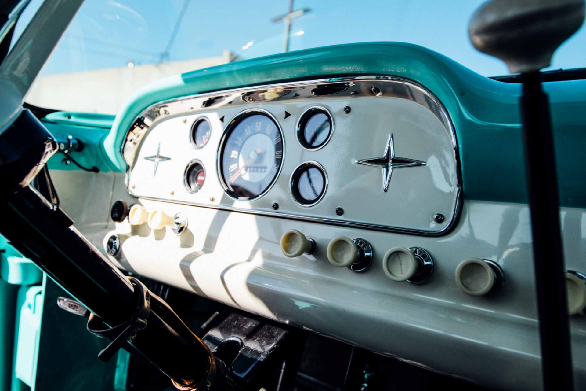 Restored cream-and-turquoise dashboard with gauges and star emblem