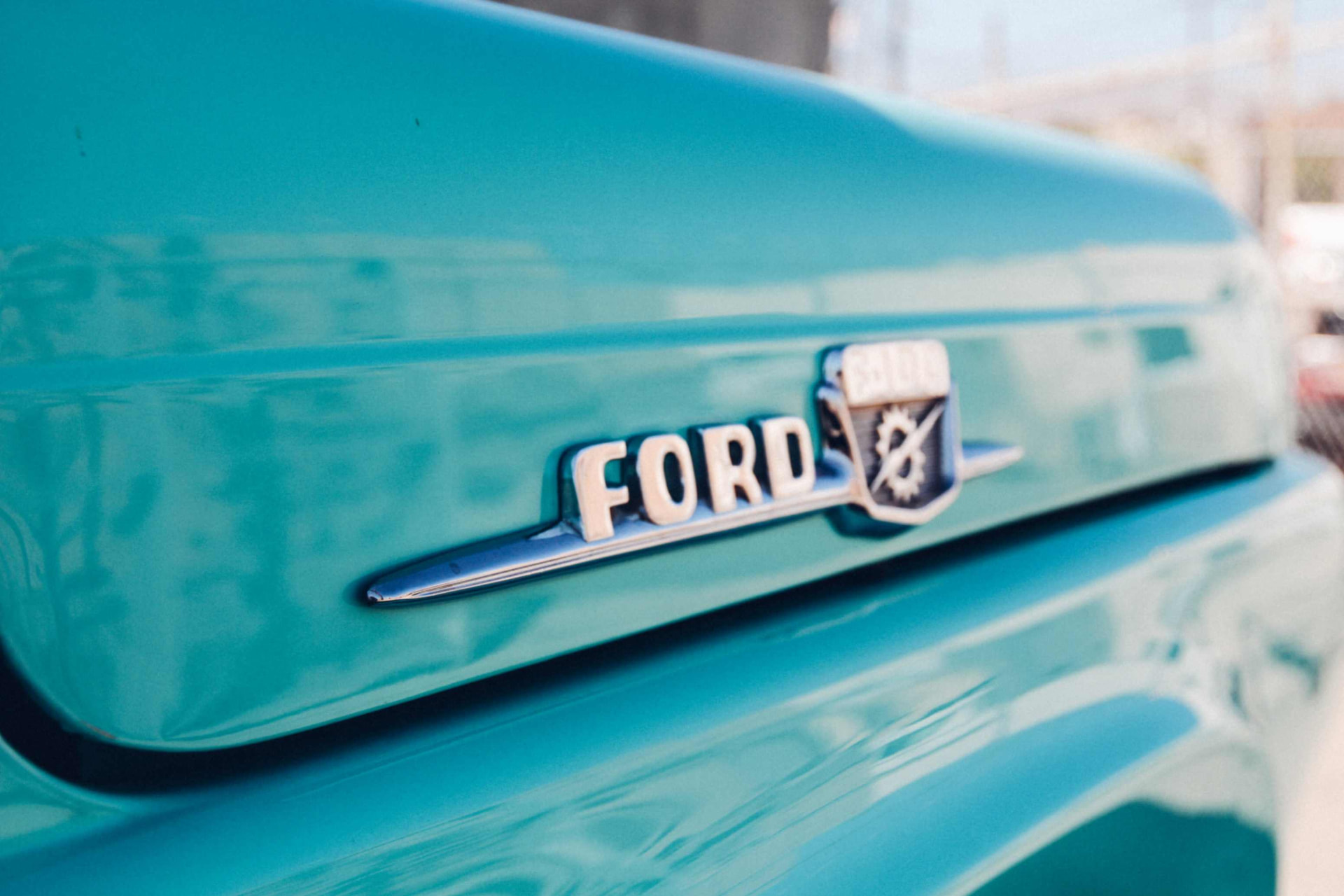 FORD hood emblem close-up on the turquoise paint