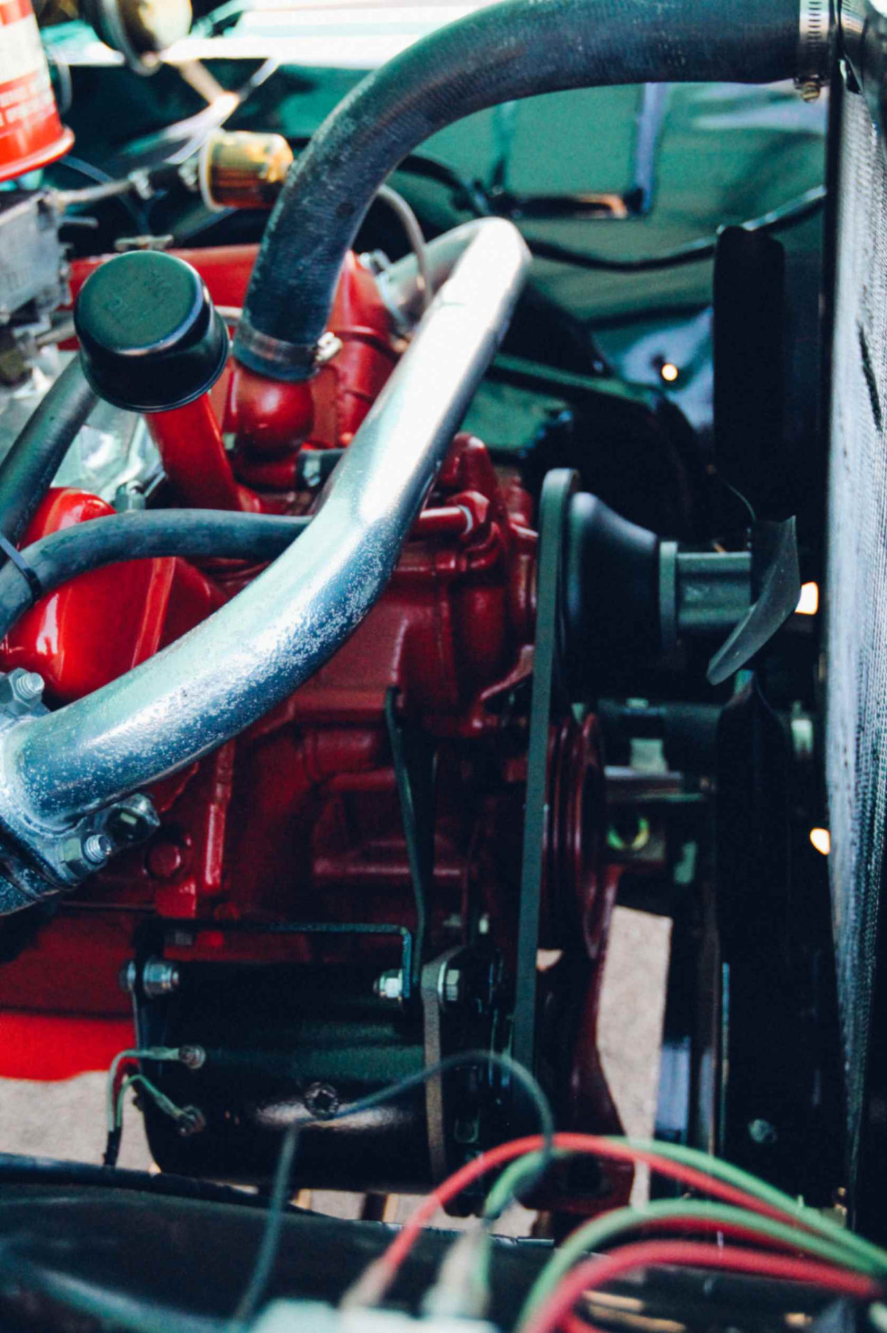 Front of the red V8 with fan, radiator, generator, and polished coolant line