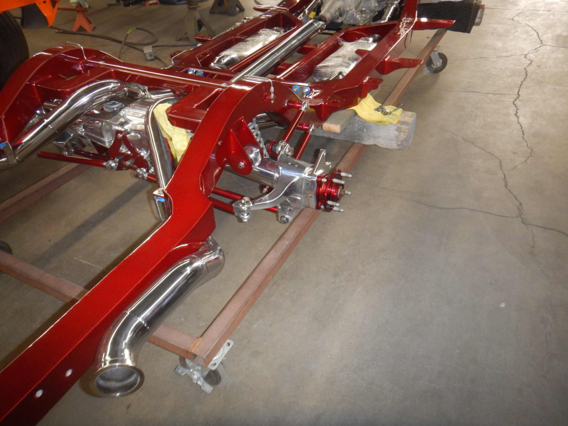 Candy-red chassis with polished exhaust and suspension